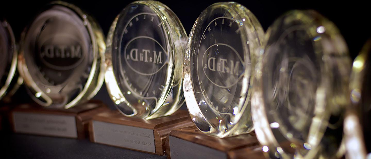 Row of glass, circular award trophies with "Matilda" engraved on it